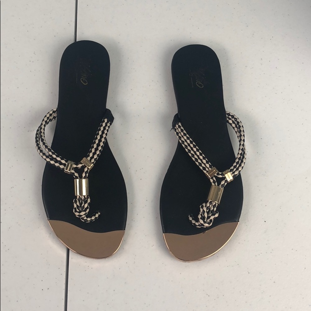 Black and white sandals with gold detail